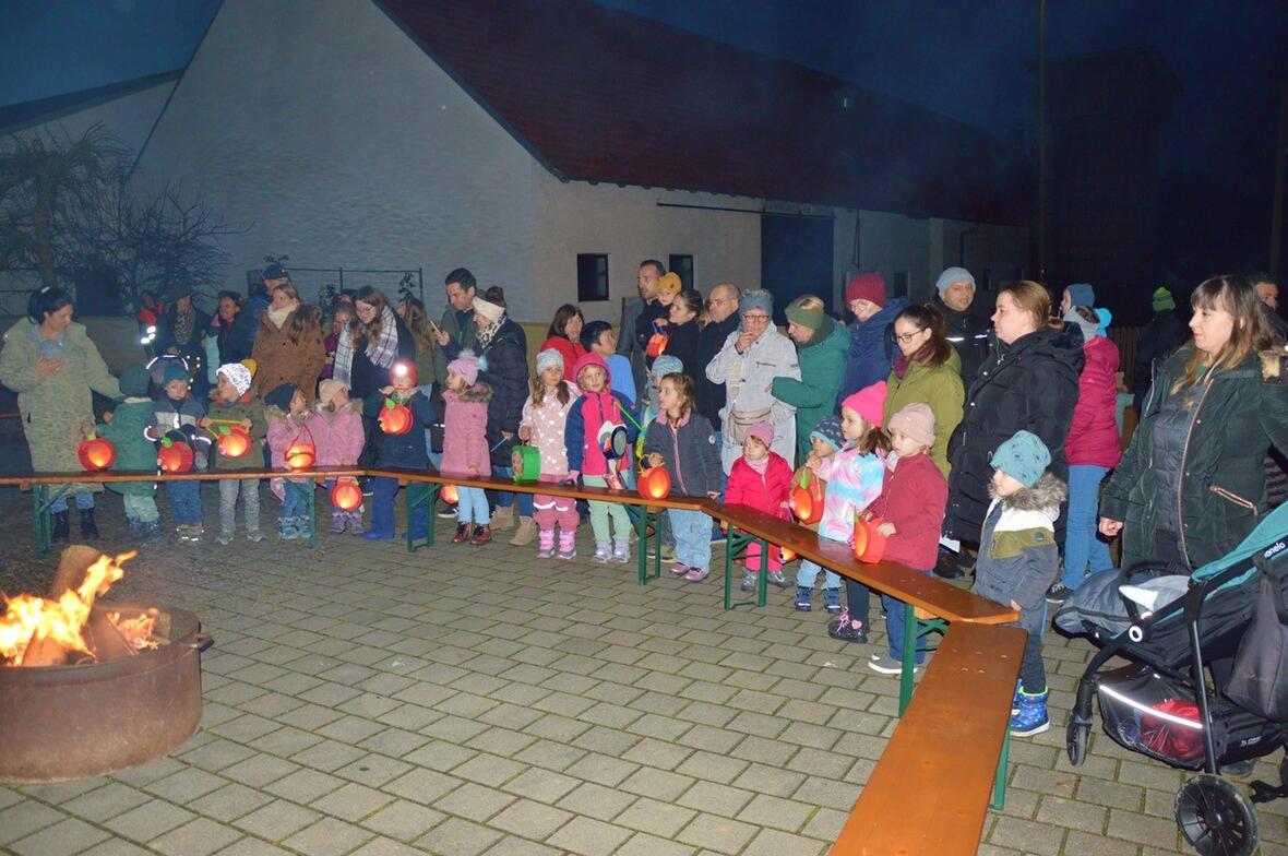 Kinder und Erwachsene mit Laternen versammeln sich am Lagerfeuer in Walda an St. Martin.