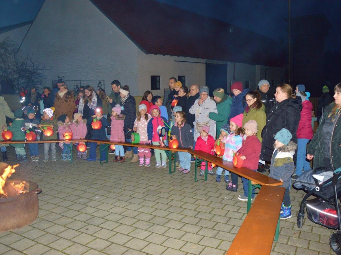 Kinder und Erwachsene mit Laternen versammeln sich am Lagerfeuer in Walda an St. Martin.