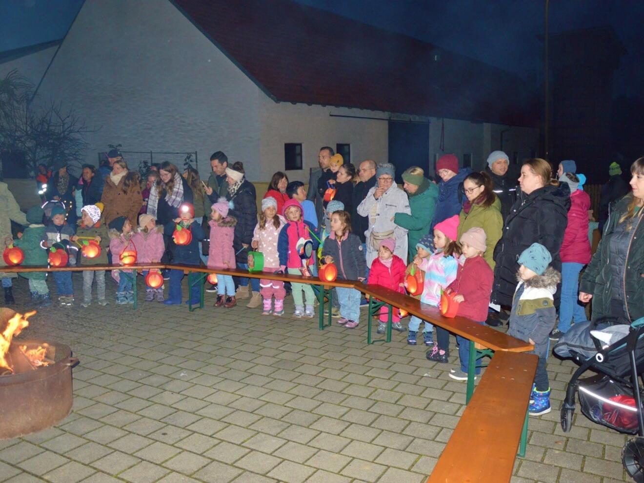Kinder und Erwachsene mit Laternen versammeln sich am Lagerfeuer in Walda an St. Martin.